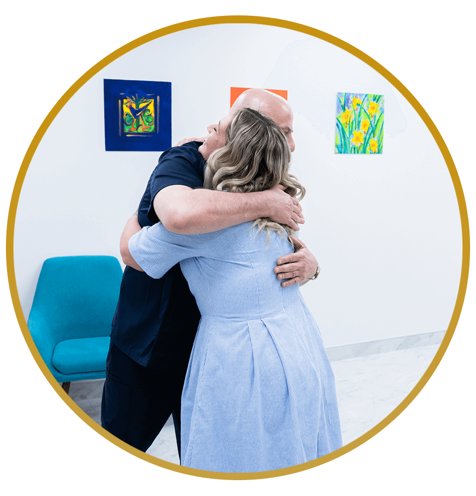 Patient hugging for helping teeth with dental implants Dr. Hamid Al-Hassin.