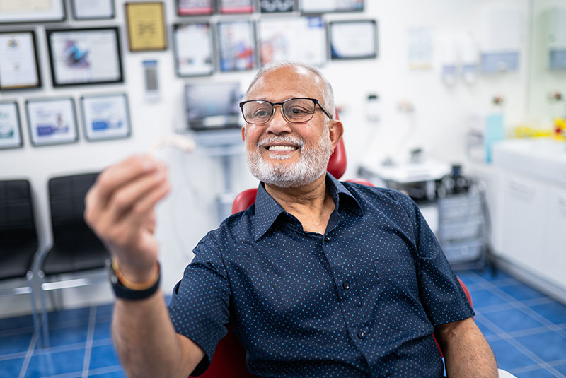 patient holding up model of a full arch